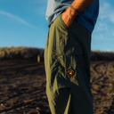 A pair of green cargo pants against a beach backdrop