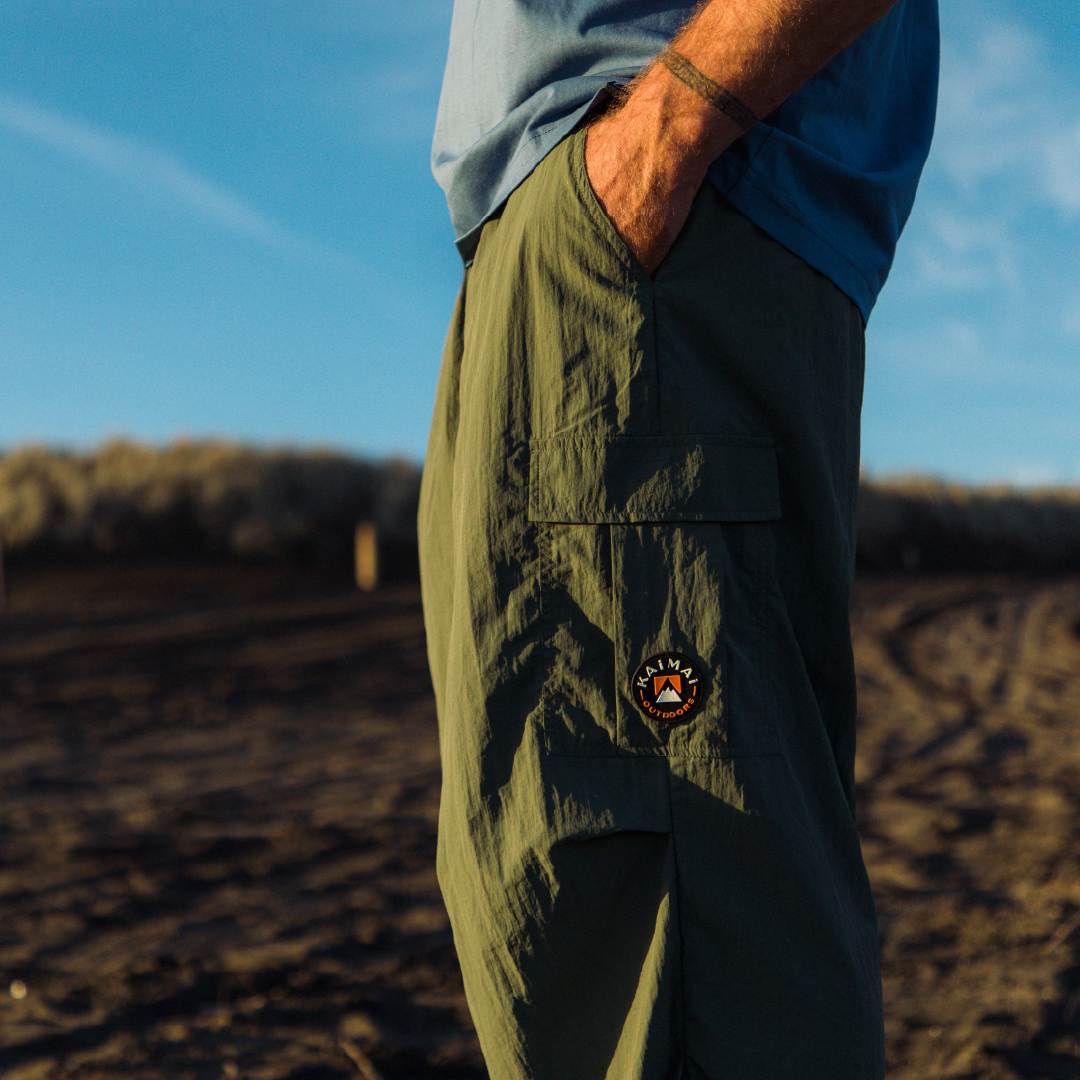 A pair of green cargo pants against a beach backdrop