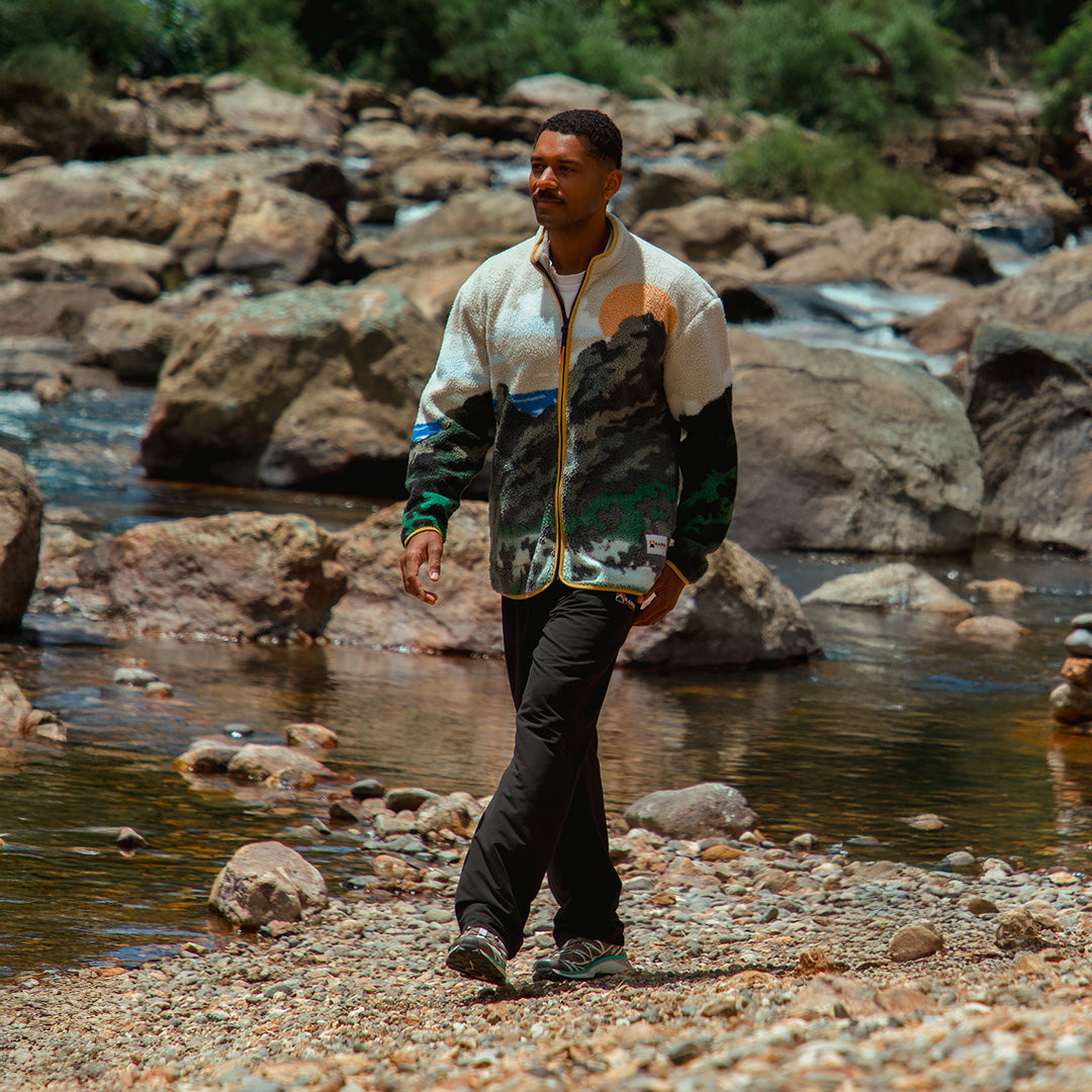 Guy weraing a sherpa jacket with a beach background